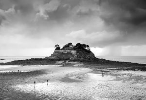 Eine Felsinsel in der Bretagne bei Ebbe, darauf befindet sich ein schönes Haus